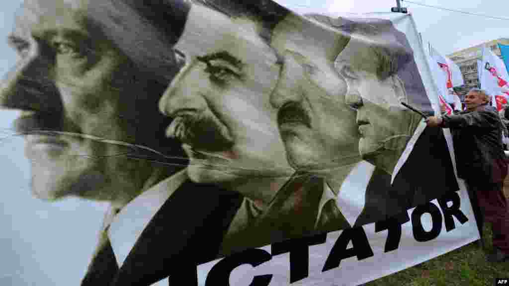 A poster with the word &quot;Dictator&quot; shows a composite picture of Adolf Hitler, Josef Stalin, Belarusian President Alyaksandr Lukashenka, and Ukrainian President Viktor Yanukovych.