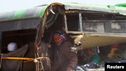 Syria -- People, who were evacuated from the two rebel-besieged Shi'ite villages of al-Foua and Kefraya, ride a bus in insurgent-held al-Rashideen, to travel to government-controlled Aleppo, April 21, 2017