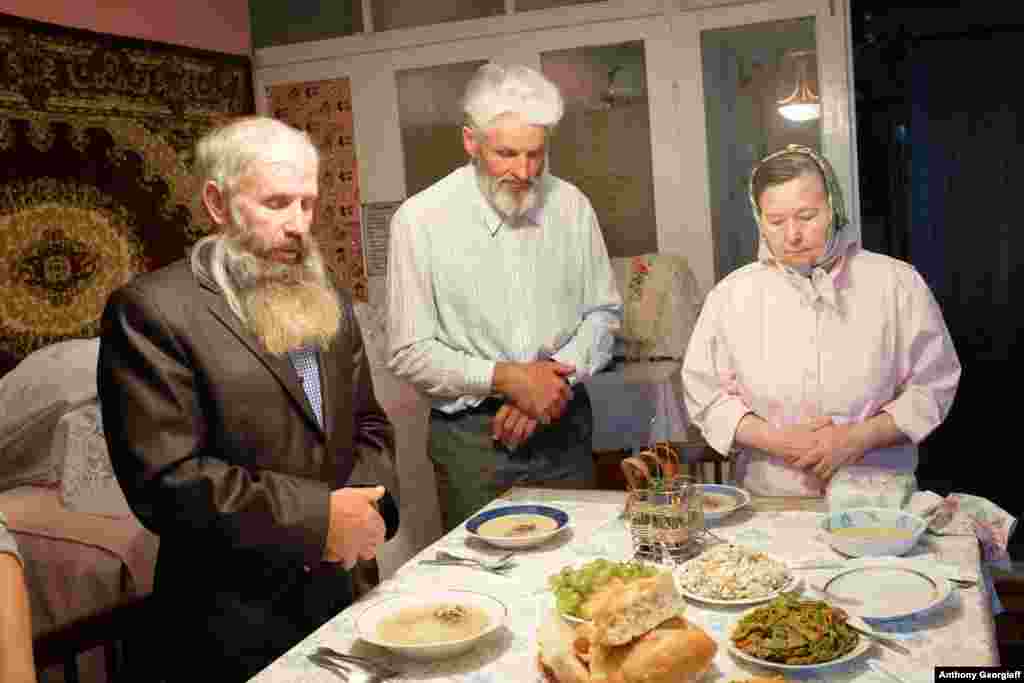 The &quot;lord of the house&quot; leads a prayer before a meal.