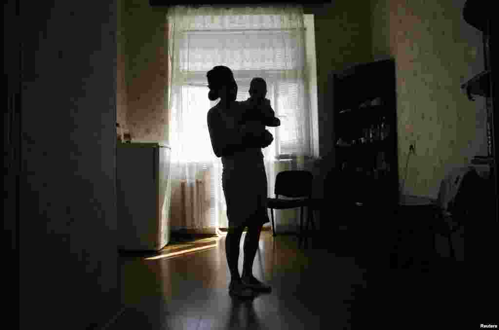 Maria Lats, 21, holds her four month-old daughter, Valeria, at a temporary shelter in the port town of Mariupol, eastern Ukraine, on March 26.&nbsp;Maria, her daughter and her husband, a Ukrainian Coast Guard officer, left the Crimean town of Kerch on March 23. (Reuters/Yannis Behrakis)