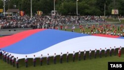 Russia -- Participants wearing t-shirts in Russian national colors take part in a theatrical performance ahead of Russia Day celebration at Moskvich Stadium, Moscow, June 11, 2014