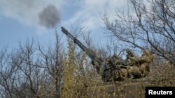 A Ukrainian serviceman fires an anti-aircraft cannon near the frontline city of Bakhmut on April 7. 