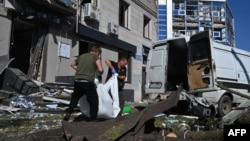 Rescue workers remove the body of a local resident killed by a Russian air strike in the center of Kharkiv on June 22.