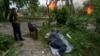 Чоловік лежить на землі, спостерігаючи за своїм палаючим будинком, зруйнованим російською авіацією у Вовчанську, Україна, 11 травня 2024 року. Фото ілюстративне