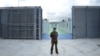 (FILES) An Italian police officer stands in a recently build Italian-run migrant centre at the port of Shengjin, some 60 kms northwest of Tirana, on October 11, 2024.