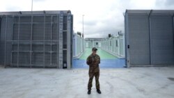 (FILES) An Italian police officer stands in a recently build Italian-run migrant centre at the port of Shengjin, some 60 kms northwest of Tirana, on October 11, 2024.