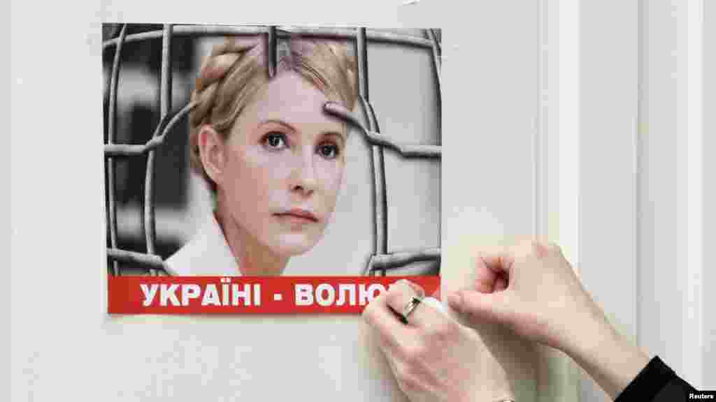 A woman puts a picture in support of jailed Ukrainian opposition leader Yulia Tymoshenko on a Brussels door on March 1, ahead of a two-day European Union leaders summit. (Reuters/Sebastien Pirlet)