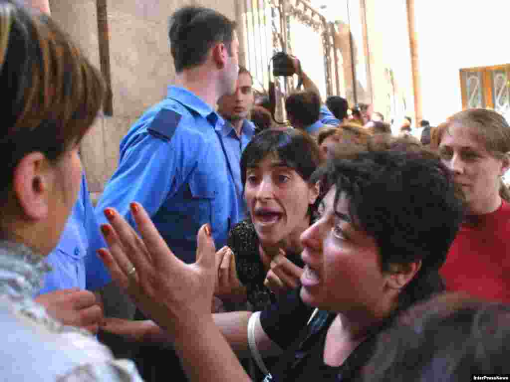 Georgian refugees from South Ossetia argue with policemen in front of the parliament in Tbilisi on August 10, 2008