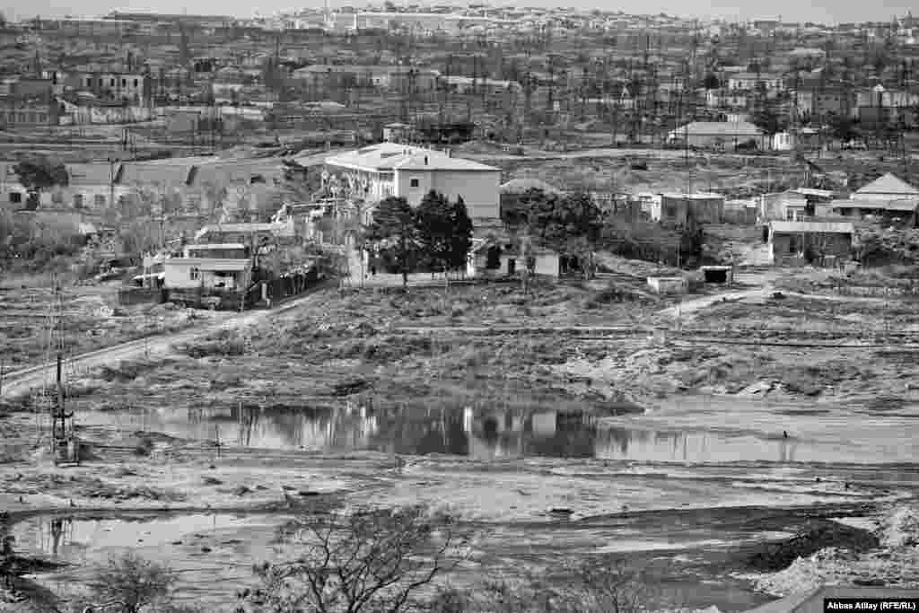 Neft buruqları, neft gölməçələri və evlər.