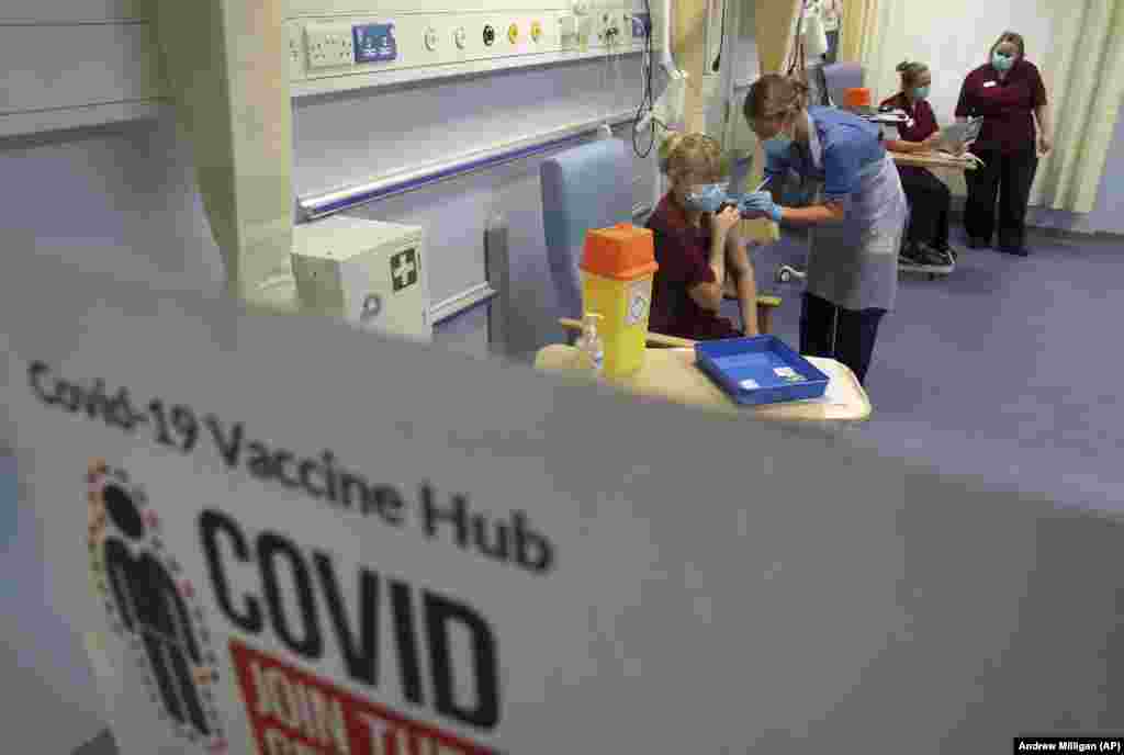 Медсестра Кэти Макинтош вводит вакцину Pfizer/BioNTech COVID-19 менеджеру медсестер клиники Фионе Черчилль в Западной больнице общего профиля в Эдинбурге. Шотландия, 8 декабря 2020 года
