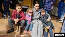 U.S. actress and UNHCR Special Envoy Angelina Jolie poses for a picture with children in Lviv on April 30. 