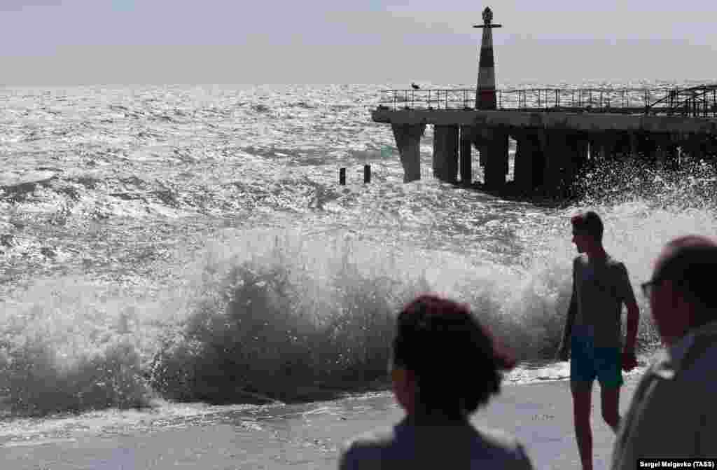 People watch the Black Sea during a storm in Alushta on the southern coast of Ukraine&#39;s Crimean Peninsula. (TASS/Sergei Malgavko)