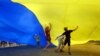 Ukrainian children under a giant national flag in Kyiv in August 2010. 