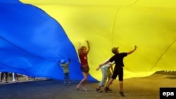 Ukrainian children under a giant national flag in Kyiv in August 2010. 