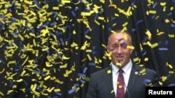 Ramush Haradinaj, candidate for prime minister of the coalition of the AAK, PDK and NISMA, smiles behind falling confetti as he campaigns in Ferizaj on June 5.