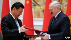 Belarusian President Alyaksandr Lukashenka (right) exchanges documents with Chinese counterpart Xi Jinping during a signing ceremony in Minsk on May 10.