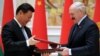 Belarusian President Alyaksandr Lukashenka (right) exchanges documents with Chinese counterpart Xi Jinping during a signing ceremony in Minsk on May 10.