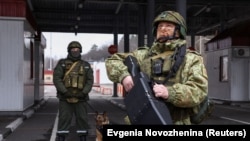 A Belarusian soldier stands with anti-drone device at a border crossing post, on the border with Ukraine.