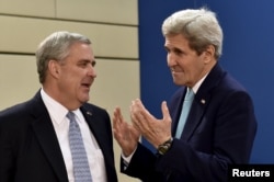 Then-U.S. Secretary of State John Kerry (right) speaks with Douglas Lute, then the U.S. ambassador to NATO, in Brussels in December 2015.