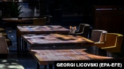 Një macë qëndron pranë tavolinave të zbarzta në një restorant në Shkup. Nëntor, 2020. 