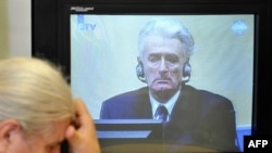 Žena, koja je preživjela genocid u Srebrenici plače dok gleda prenos prvog pojavljivanja Radovana Karadžića pred tribunalom u Hagu