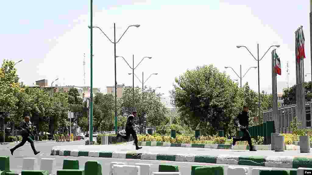 Полиция қызметкерлері Иран парламенті ғимаратына қарай жүгіріп барады​.