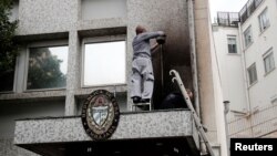 Работници ја чистат изгорената фасада на Кубанската амбасада во Париз