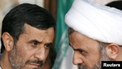 Iranian President Mahmud Ahmadinejad (left) speaks with Hizballah senior Sheikh Nabil Kawooq during a rally organized by Lebanon's Hizballah in Bint Jbeil on October 14.