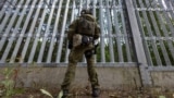 Польский пограничник на польско-белорусской границе перед ограждением. Пункт Половце-Пещатке, Польша, 21 июля 2025 года