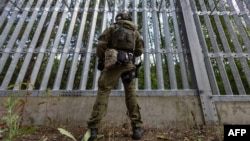 Польский пограничник на польско-белорусской границе перед ограждением. Пункт Половце-Пещатке, Польша, 21 июля 2025 года