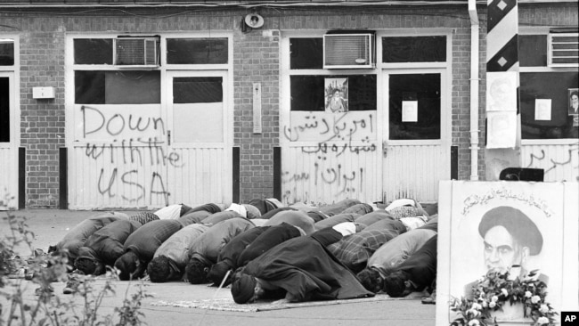 Iranian students pray inside the American Embassy compound before anti-American slogans on the third day of the occupation of the embassy in Tehran, Iran on Nov. 6, 1979. Sixty people are still held hostage against the deportation of the former Shah of Ir
