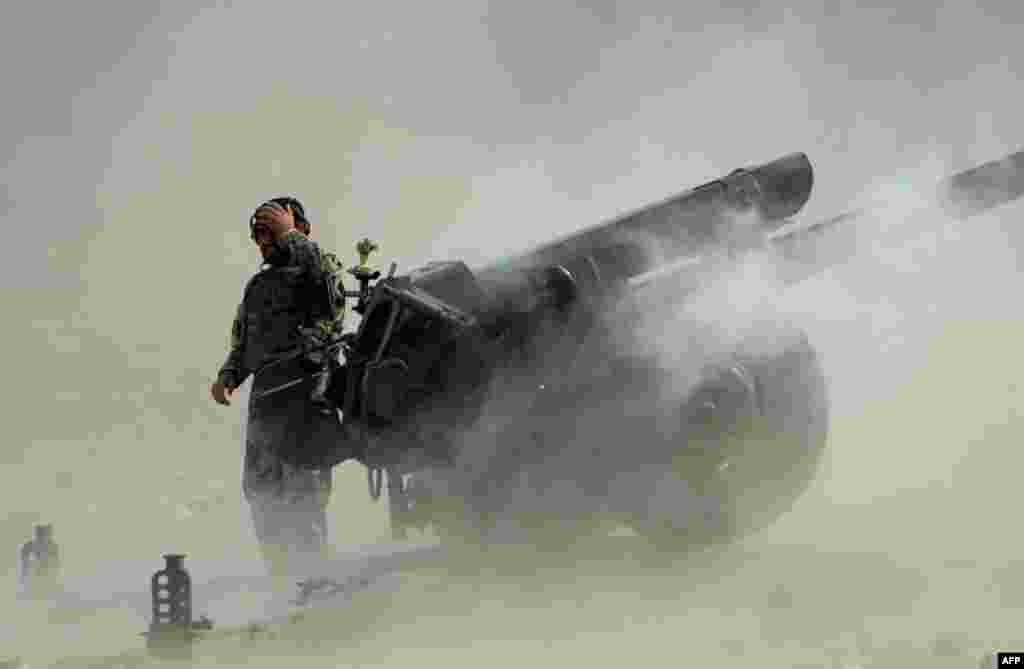 An Afghan National Army soldier fires an artillery shell during ongoing clashes between Afghan security forces and militants in the Kot district of Nangarhar Province. (AFP/Noorullah Shirzada)