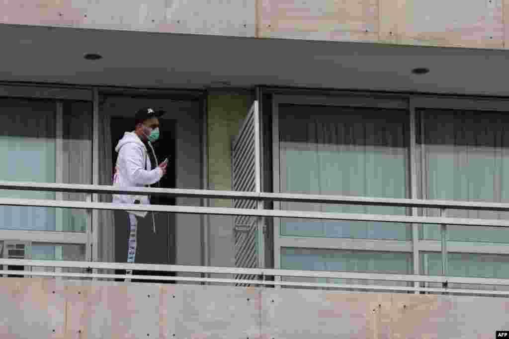Човек на балкон во хотел во Атина каде што заедно со други лица е сместен во двонеделен карантин, откако грчката влада воведе национална забрана за движење да го спречи ширењето на коронавирусот.