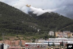Avionispušta vodu u pokušaju da ugasi požar na padini iza grada Aquila, u planinskoj regiji Abruzzo, centralna Italija, u utorak, 4. augusta 2020.