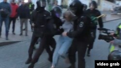 A screenshot of the video shows the officer punching the woman in the stomach.