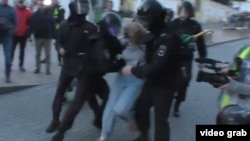 Moskwada egni formaly bir ofiseriň saklanan bir zenan protestçiniň garnyna ýumruk bilen urýanyny görkezýän wideo ýazgydan alnan surat