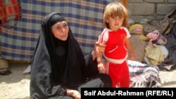 سيدة عراقية فقيرة مع طفلتها