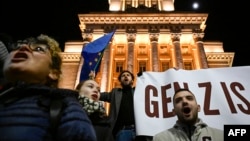 Протестиращ държи знамето на ЕС и транспарант на "поколението Z" по време на антиправителствения протест на площад "Независимост" в София на 1 декември 2025 г. Десетки хиляди хора излязоха на протести в България през тази седмица.