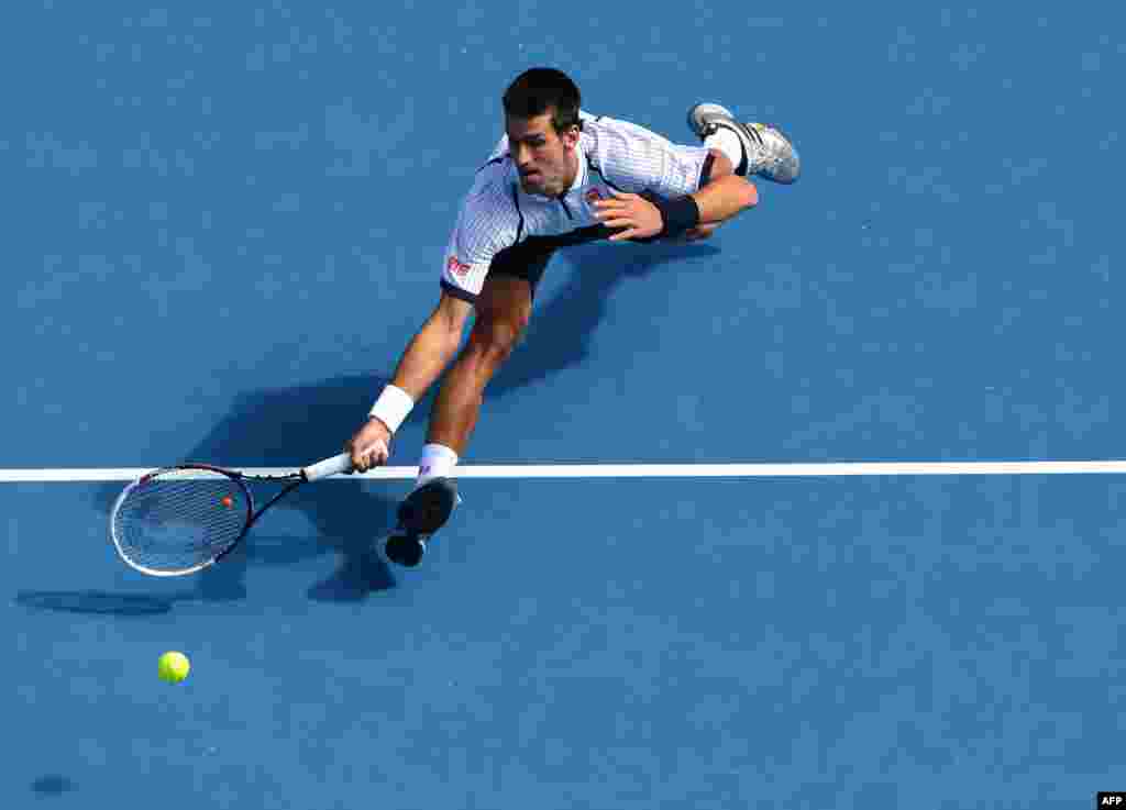 Serbia's Novak Djokovic stretches to return a shot during his men's singles match against Czech Republic's Radek Stepanek at the Australian Open tennis tournament in Melbourne. (AFP/William West)