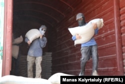 На фото — грузчики на станции Шетпе разгружают отруби, привезенные из Костанайской области