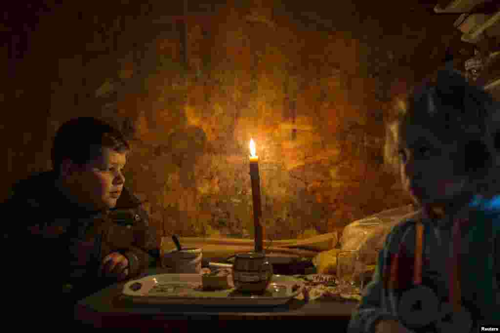 Lazar and his sister Andjelka sit by a candle in their home in the eastern Serbian town of Majdanpek. (Reuters/Marko Djurica)