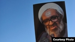 Iranians hold portraits of Iranian cleric Grand Ayatollah Hossein Ali Montazeri during his funeral procession in the holy city of Qom, 21Dec2009