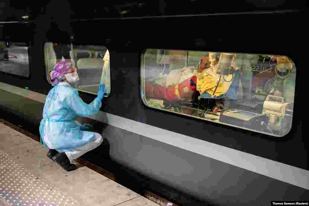 A medical worker looks through the window of a French high-speed train before evacuating coronavirus patients from Paris to Brittany on April 1.