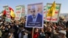 A person holds a sign showing the late Hamas leader Yahya Sinwar as protesters rally to show support to Lebanon's Hezbollah and Palestinians in the Gaza Strip, in Sanaa, Yemen, on October 18.