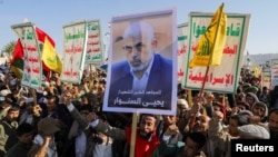 A person holds a sign showing the late Hamas leader Yahya Sinwar as protesters rally to show support to Lebanon's Hezbollah and Palestinians in the Gaza Strip, in Sanaa, Yemen, on October 18.