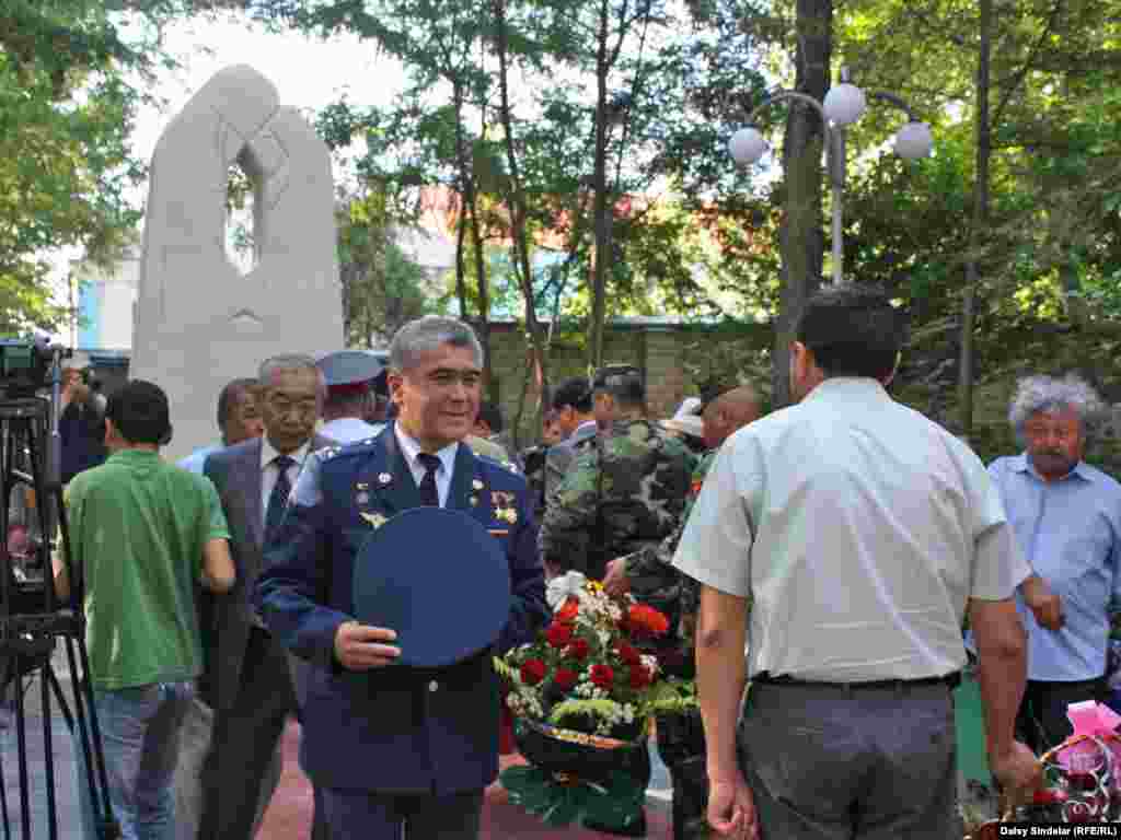 Kyrgyz officials pay their respects at the newly unveiled monument honoring the victims of the June 2010 clashes between ethnic Uzbeks and Kyrgyz, which left 470 people dead. The monument, of cast stone, depicts two mothers embracing, one Kyrgyz, one Uzbek. Photo by RFE/RL's Daisy Sindelar 