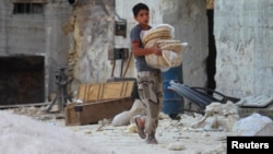 A boy carries bread in the Syrian city of Latamneh, which was reportedly hit two days ago by Russian air strikes. 