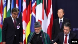 NATO Secretary-General Anders Fogh Rasmussen (right) and Afghan President Hamid Karzai sign a long-term security partnership in Lisbon on November 20. But will the partnership endure?