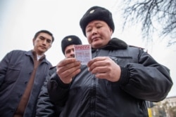Сотрудник полиции проверяет документы у журналистов. Алматы, 22 февраля 2020 года.