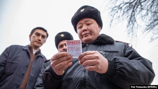 Сотрудник полиции проверяет документы у журналистов. Алматы, 22 февраля 2020 года.